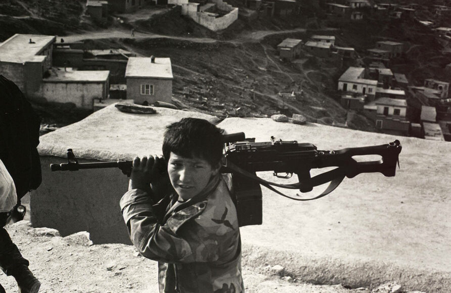 MICHEL COMTE. 12-year-old with machine gun Afghanistan, 1995. © Michel Comte / Courtesy of CAMERA WORK Gallery.
