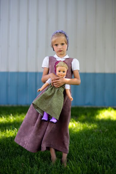 Nevada Waldner posiert für ein Porträt mit ihrer Puppe im Stil von American Girl in der Maple Grove Colony. Die von Familienmitgliedern selbst genähte Kleidung spiegelt das Leben der hutterischen Mädchen wider, Juni 2016. Foto: Tim Smith